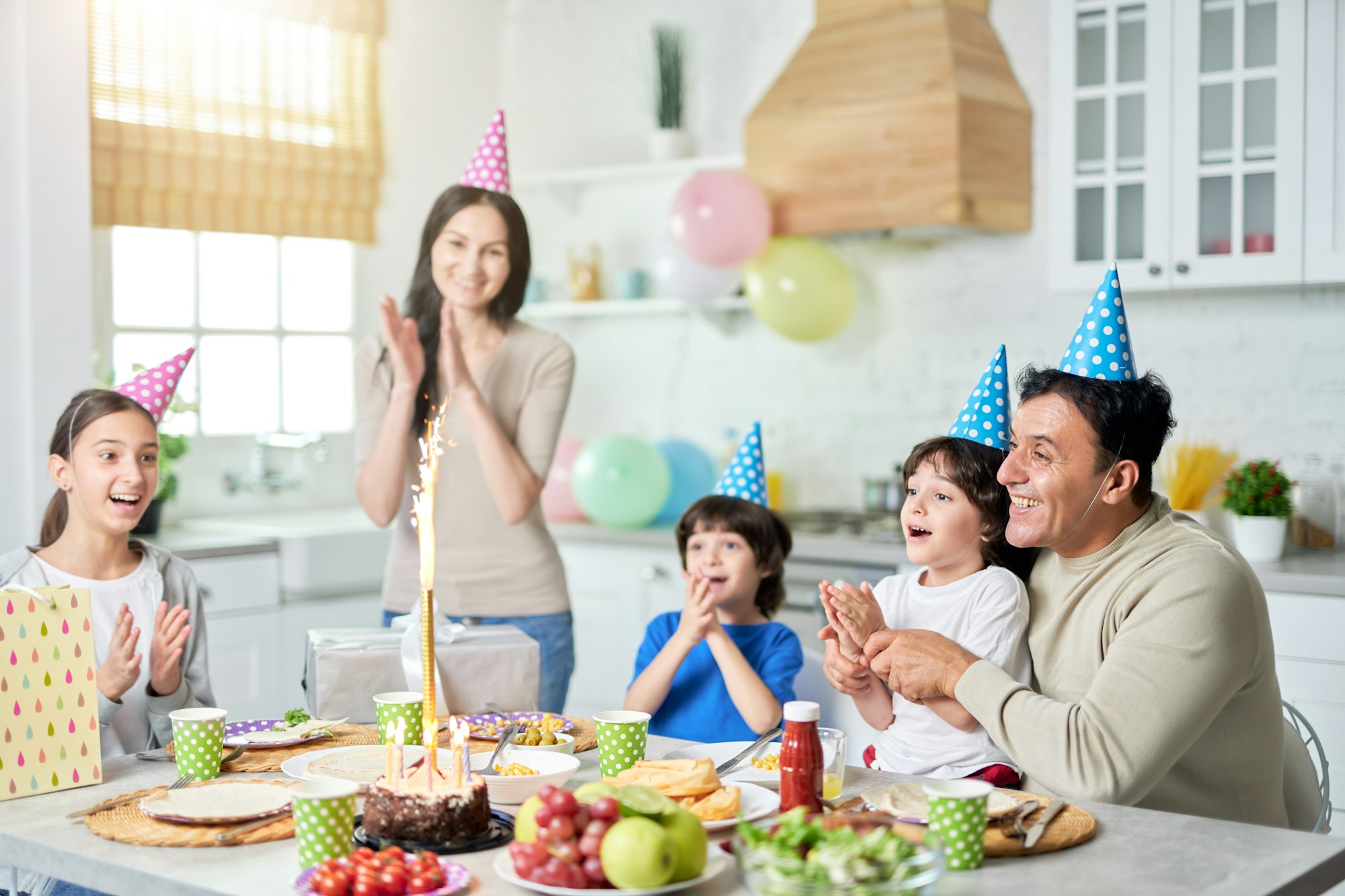 Special day. Joyful hispanic family with children looking happy, clapping while celebrating birthday
