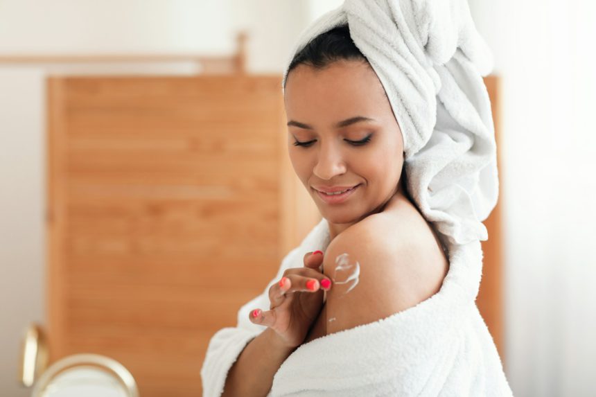 Woman Applying Moisturizer On Shoulders Caring For Body In Bathroom